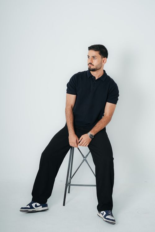 Free Casual portrait of a male model in a studio setting, dressed in black. Stock Photo