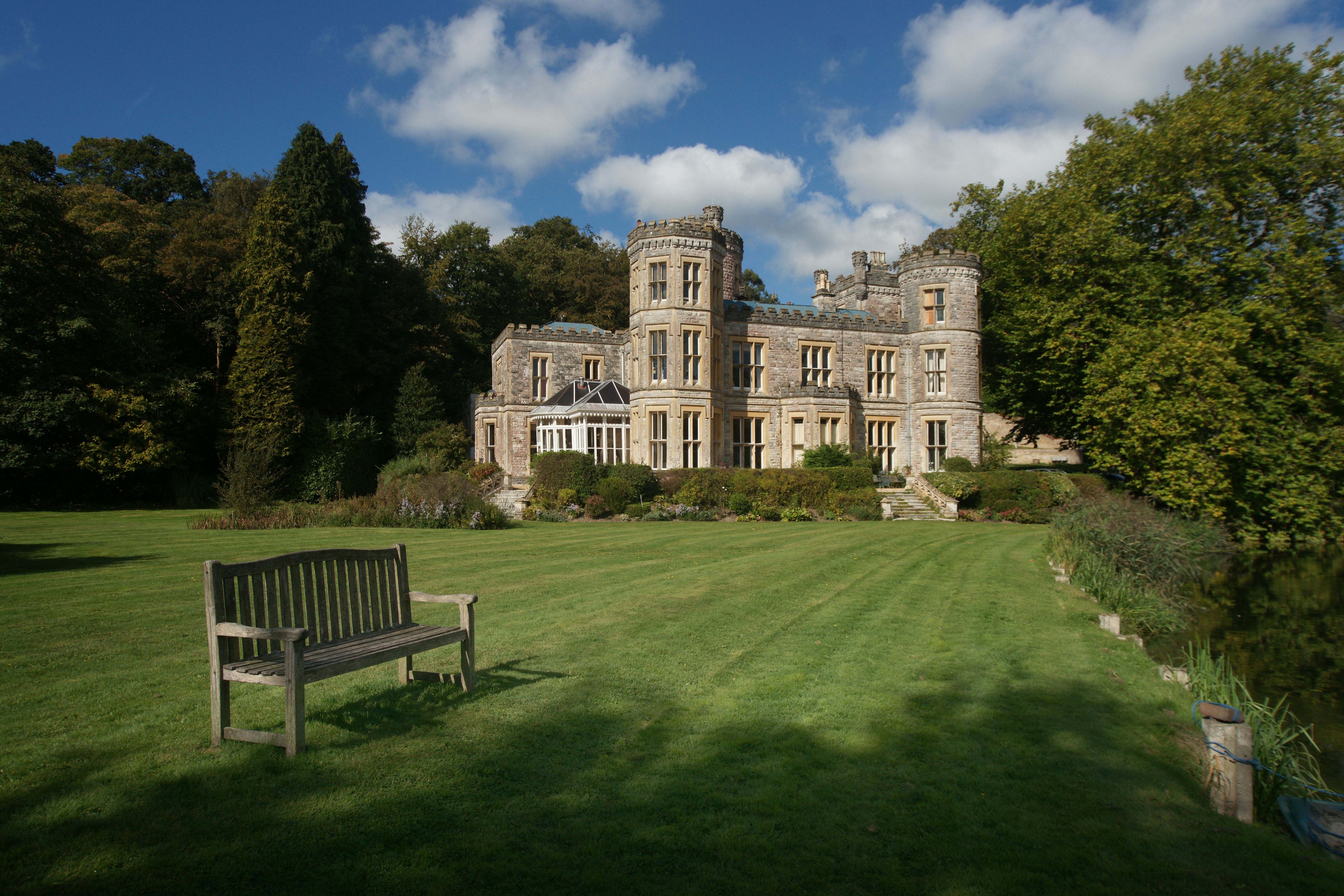 A picturesque stone castle surrounded by lush greenery under a clear blue sky in Saint Ives, England.