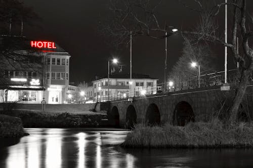無料 川の近くのホテルのグレースケール写真 写真素材