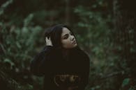 一幅描绘女人在黑暗森林中沉思的肖像，传递出深度和内省