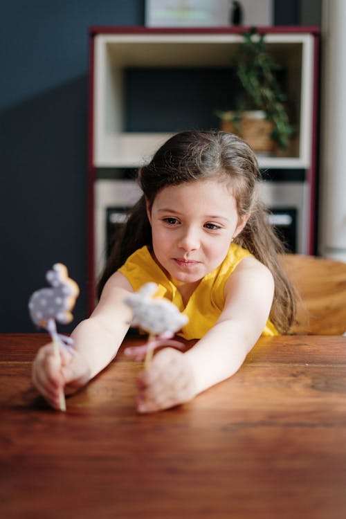 Free Girl in Yellow Tank Top Holding Bunny Lollipops Stock Photo