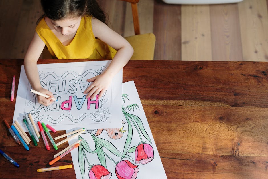 A young girl in yellow dress coloring an Easter drawing at a wooden table.