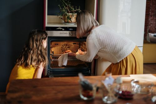 Free A mother and daughter baking a cake in a cozy kitchen setting, enhancing family time. Stock Photo