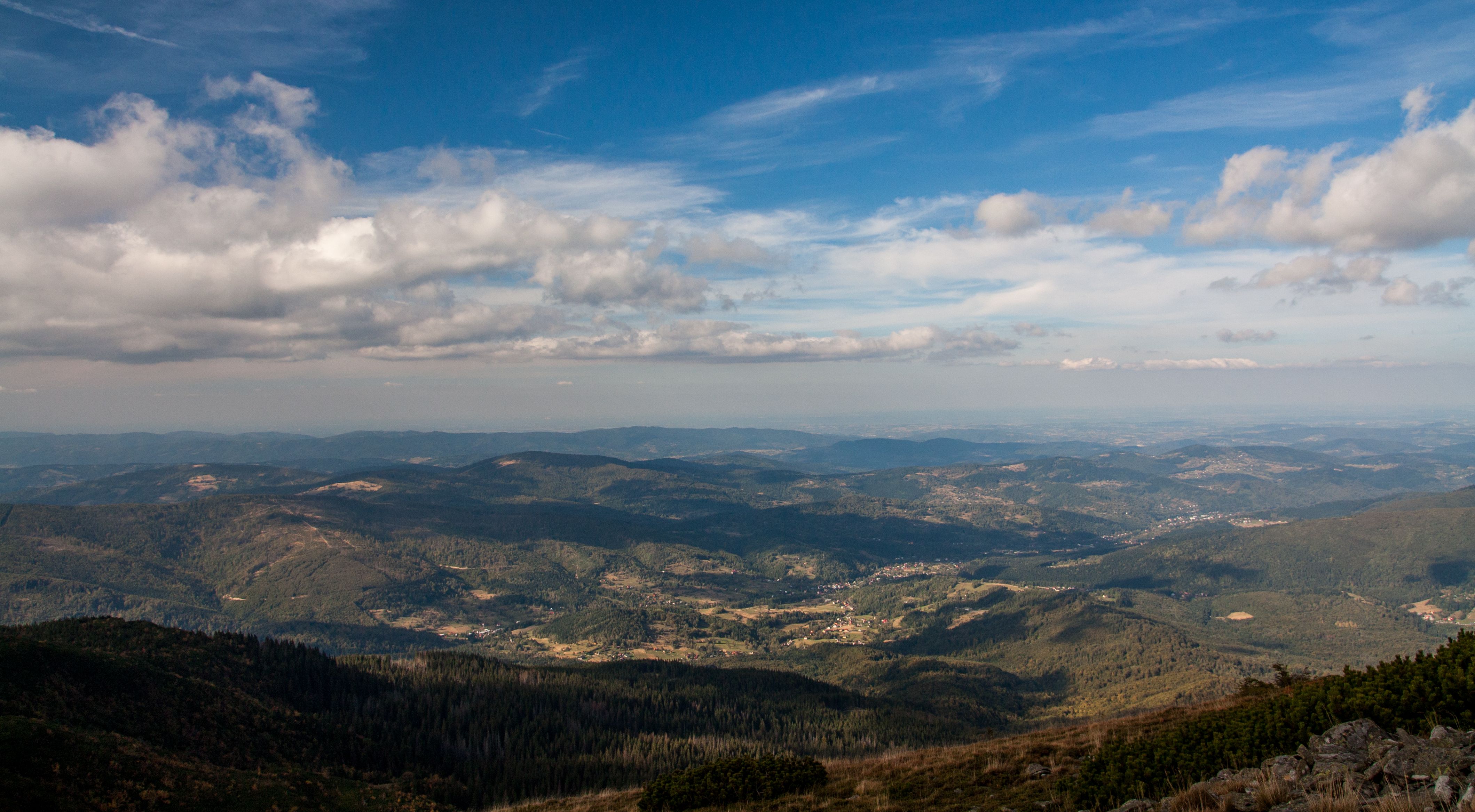 A breathtaking view of the Beskid Mountains in Poland under a blue sky.
