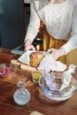 Person in White Sweater Holding Bread