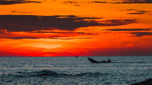Free Captivating sunset at Cửa Tùng beach with a solitary fishing boat on the horizon. Stock Photo