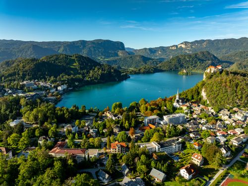 Free Stunning aerial view of Lake Bled with vibrant landscape and the town of Bled in Slovenia on a sunny day. Stock Photo