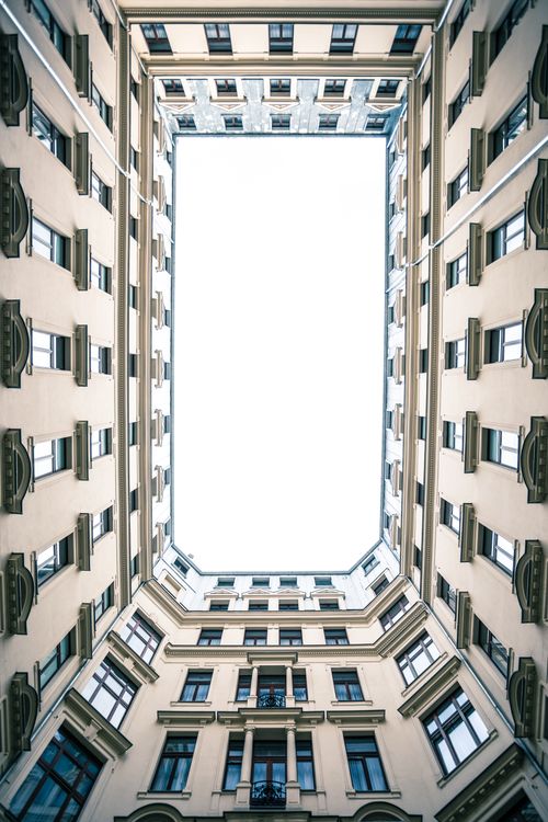 Free Looking up at a geometric architectural courtyard in Warsaw, Poland, showcasing elegant symmetry. Stock Photo