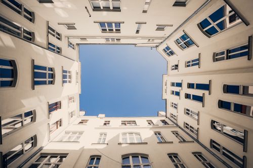 Free A stunning upward view of a courtyard in Wrocław, Poland, showcasing classic architecture and a clear blue sky. Stock Photo