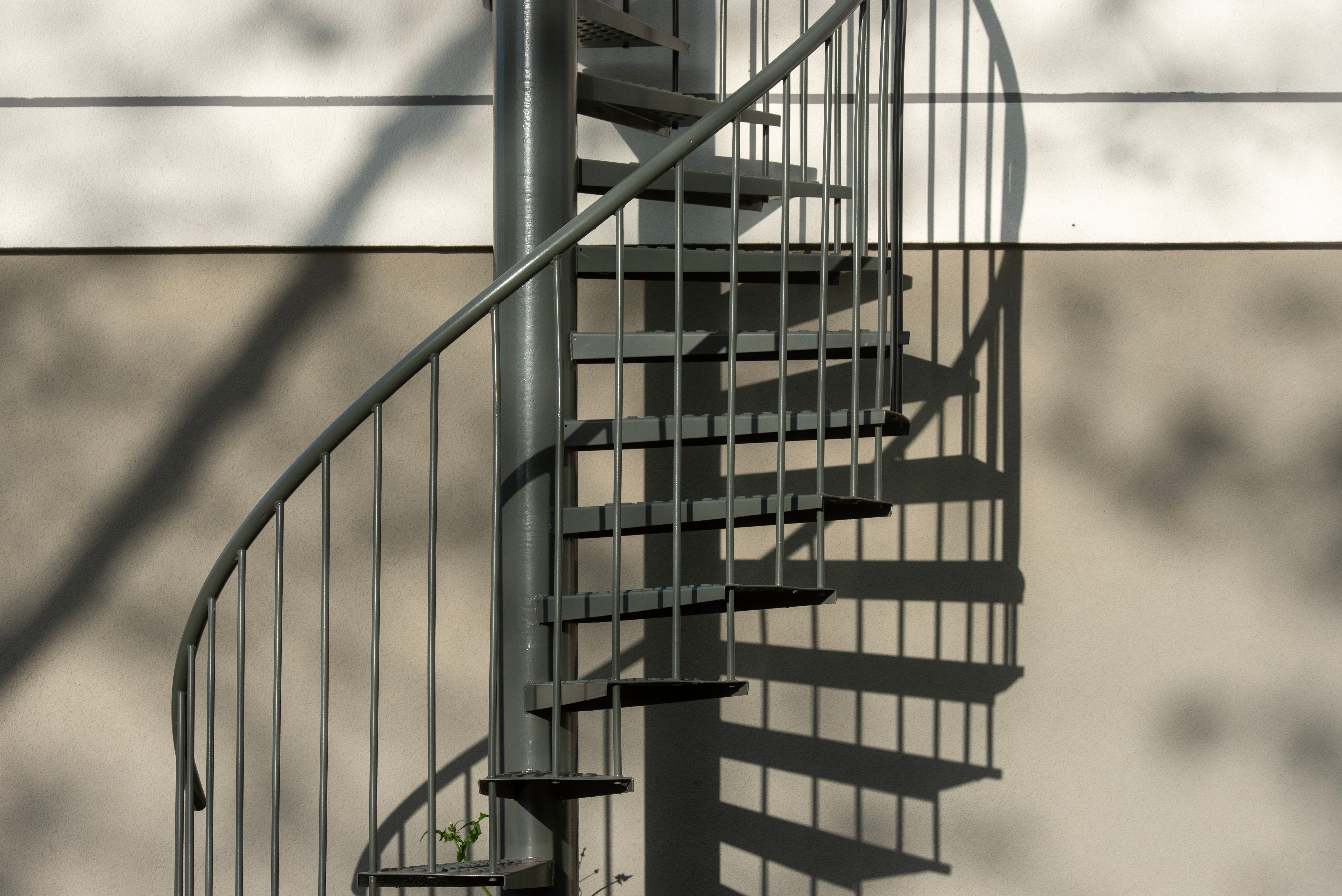 Spiral staircase shadow cast on a minimalist wall