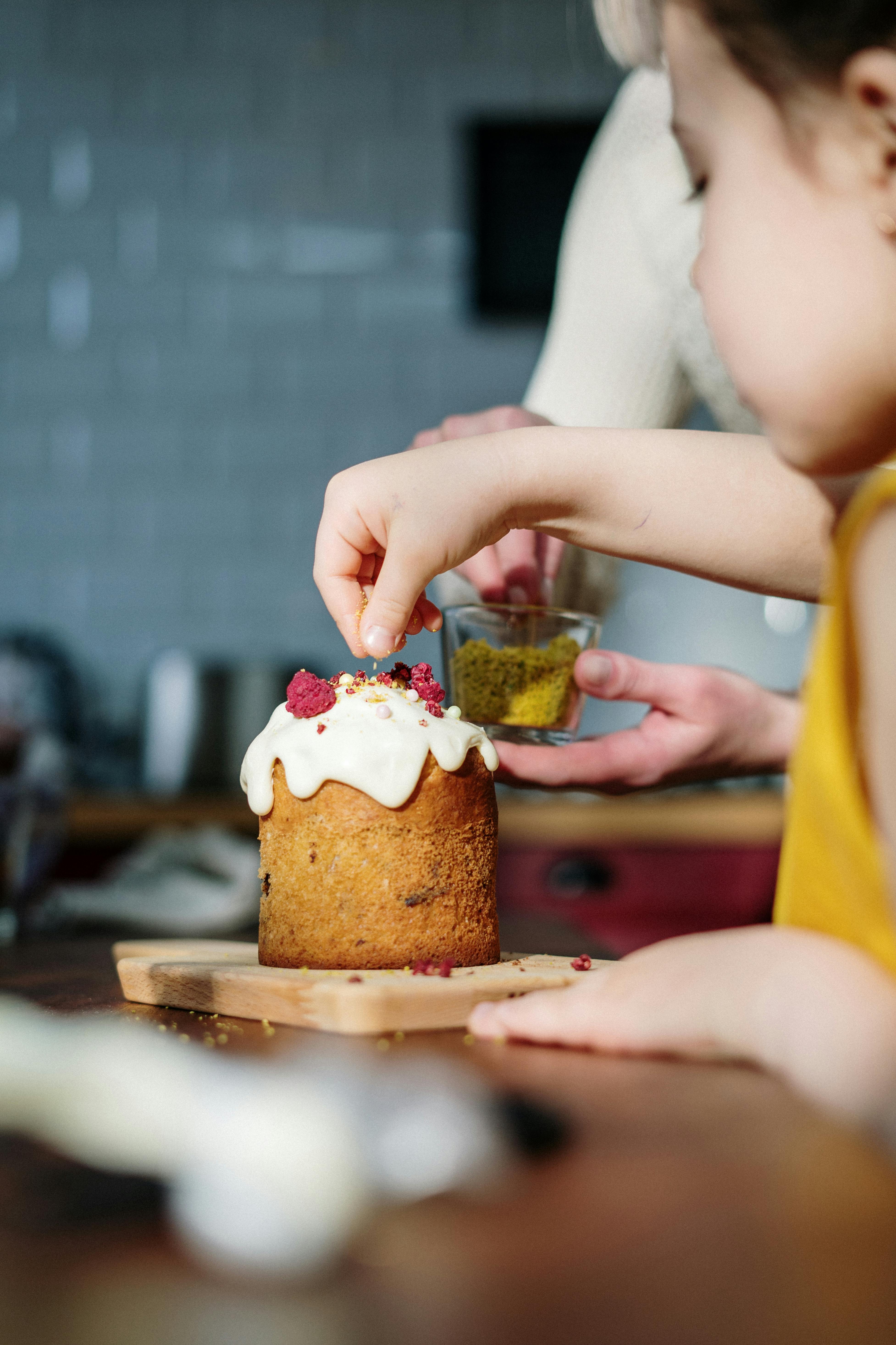 girl in yellow shirt holding brown cake