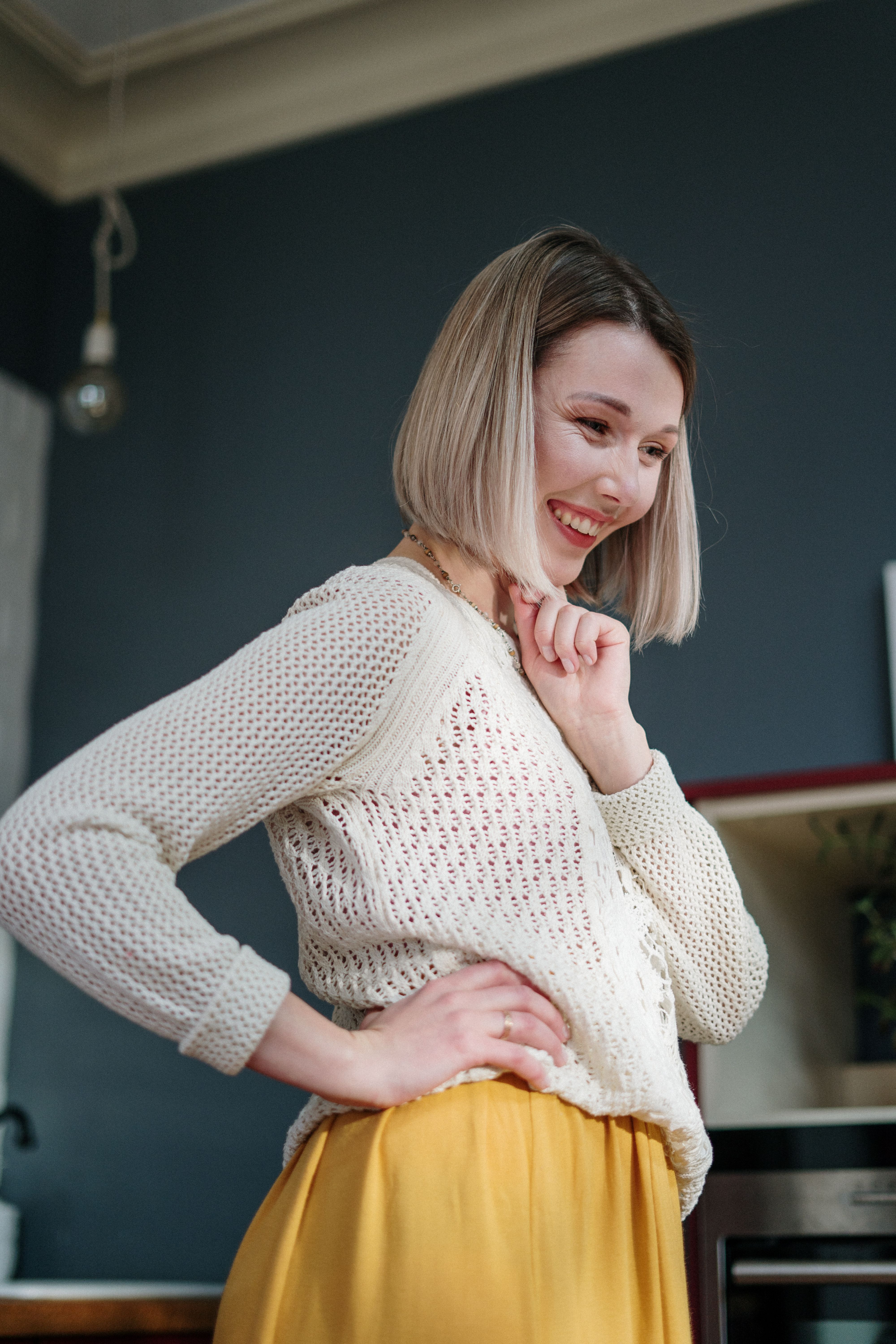 在一个舒适的室内，穿着针织毛衣的迷人女人向鲍勃露出了温暖的微笑