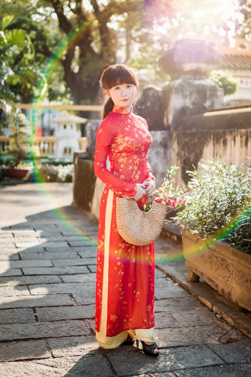 Free Girl in Red Long Sleeve Dress Standing on Gray Concrete Floor Stock Photo