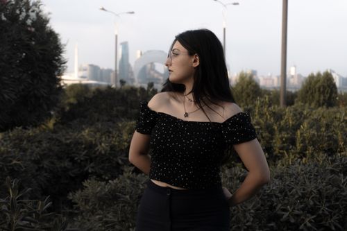Free Portrait of a young woman outdoors with Baku's iconic skyline in the background. Stock Photo