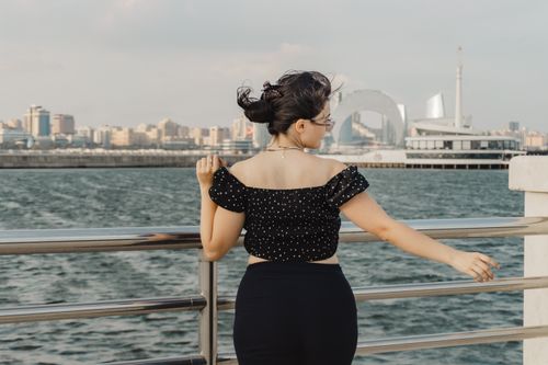 Free A woman enjoying the waterfront view with Baku cityscape in the background. Stock Photo