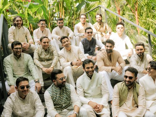 Free A vibrant group of men in traditional attire sitting outdoors amidst lush greenery. Stock Photo