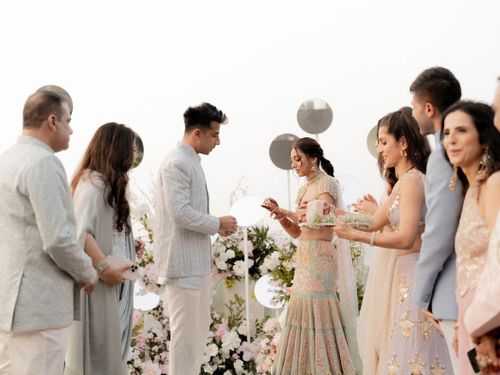 Free A beautiful outdoor wedding ceremony with traditionally dressed guests exchanging rings. Stock Photo