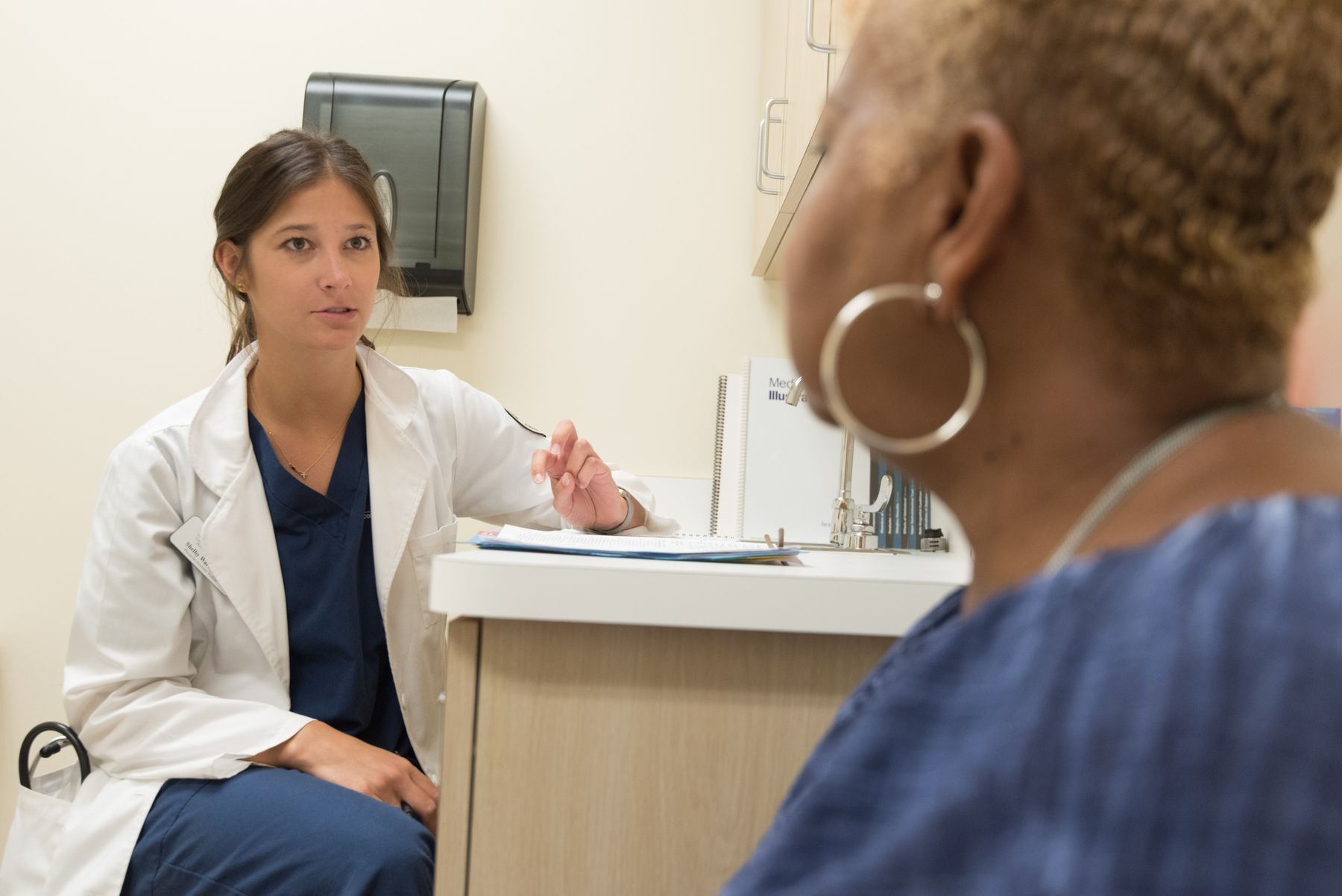 A healthcare professional speaking with a client in a modern office