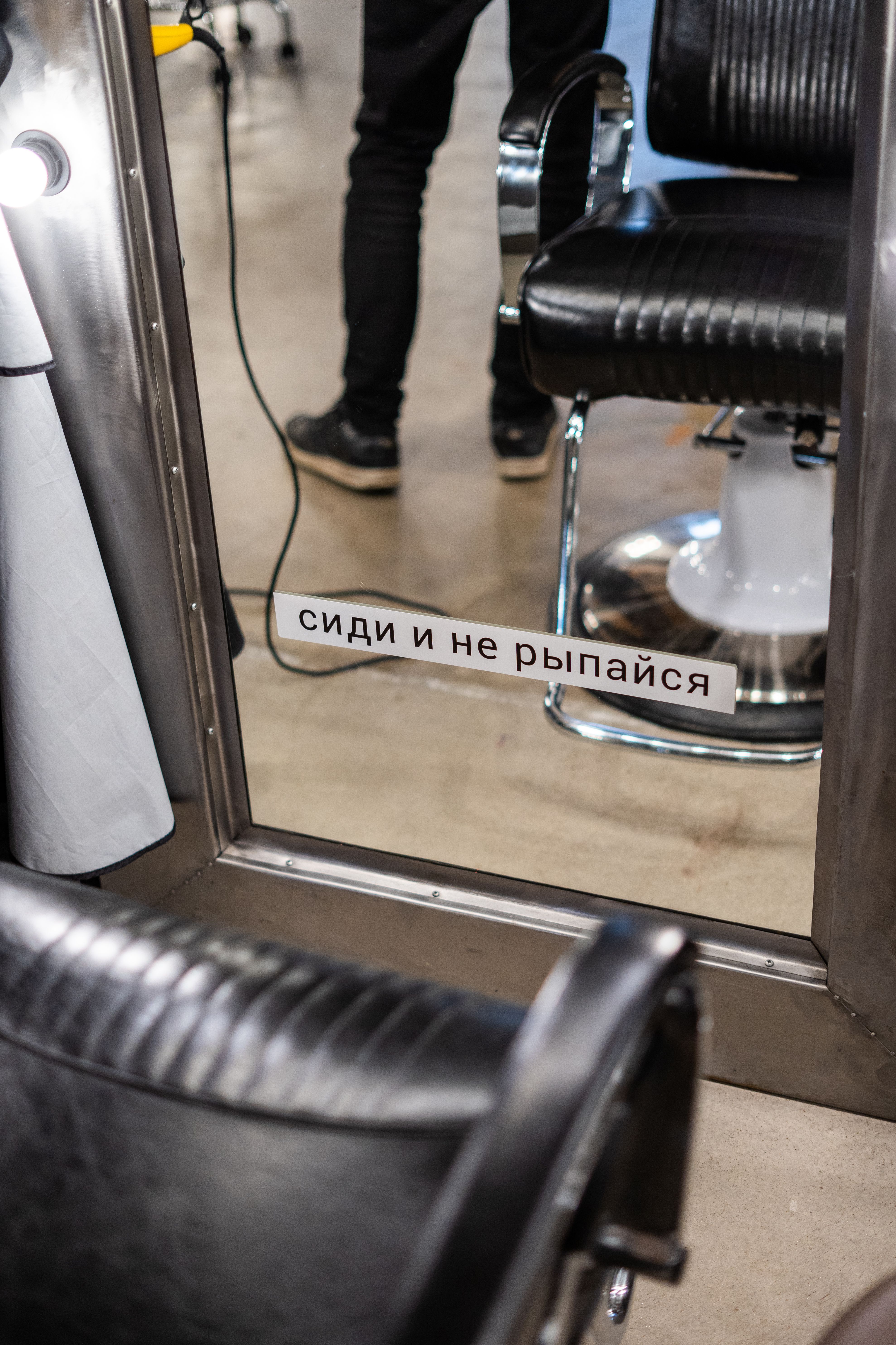 Barber shop interior with chairs and mirror featuring unique signage. Stylish and contemporary look.