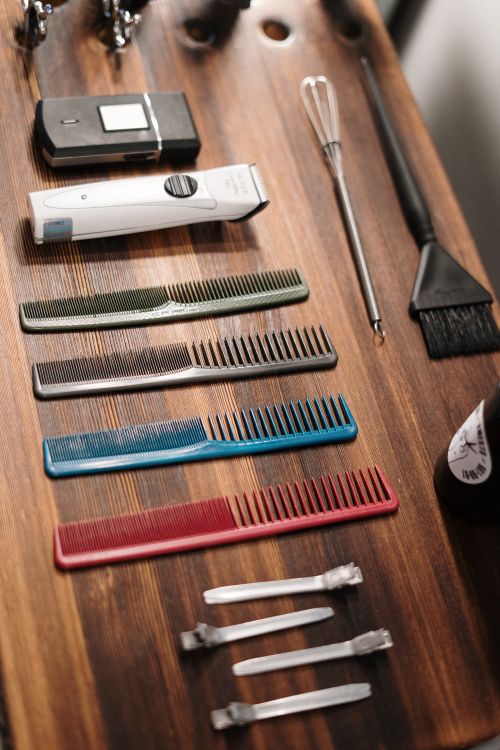 Free Organized collection of barber tools on a wooden table, ready for grooming. Stock Photo