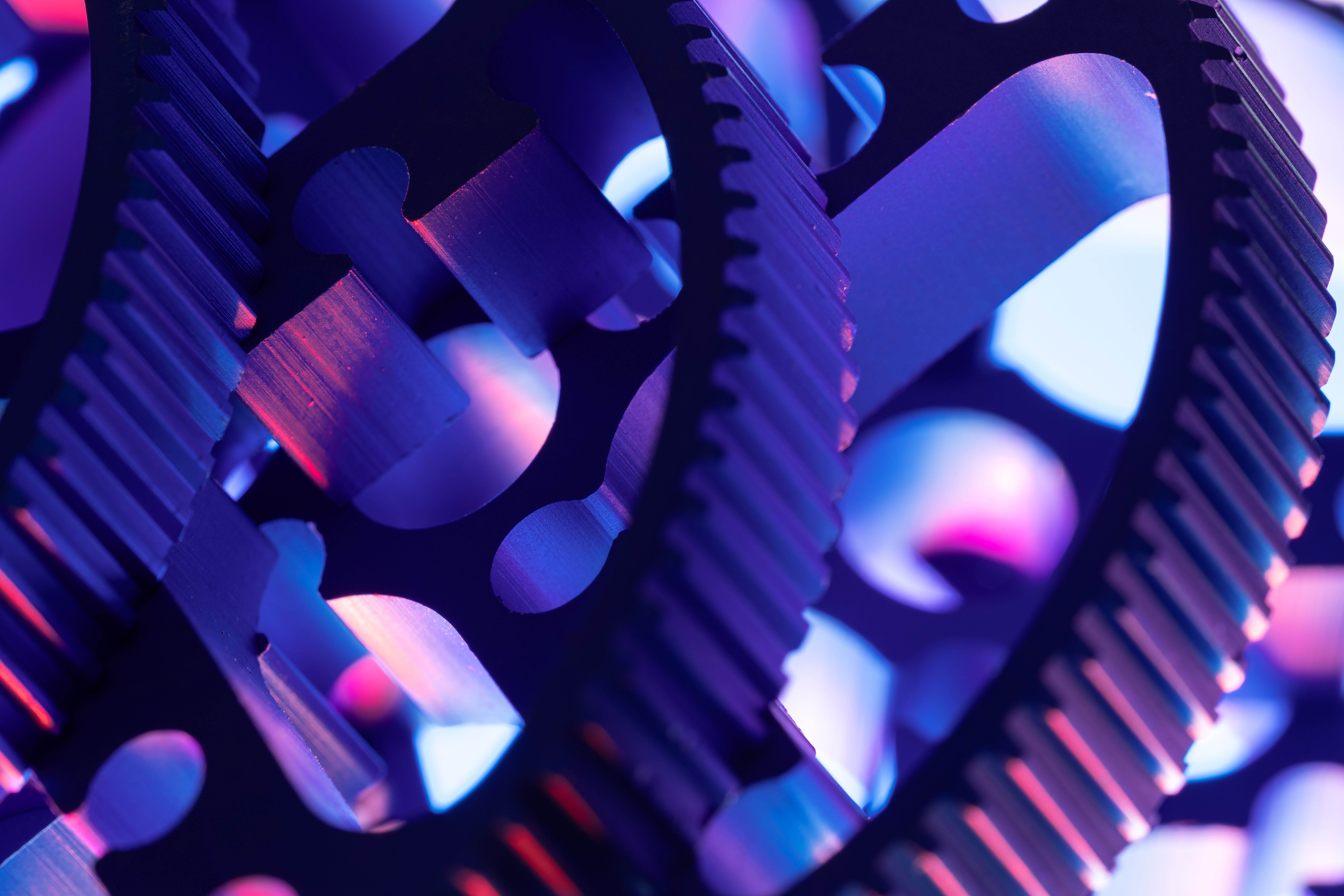 Colorful macro shot showcasing metal gears in intricate detail and vibrant lighting.