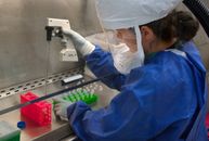 在无菌实验室环境中，一位科学家仔细处理着设备