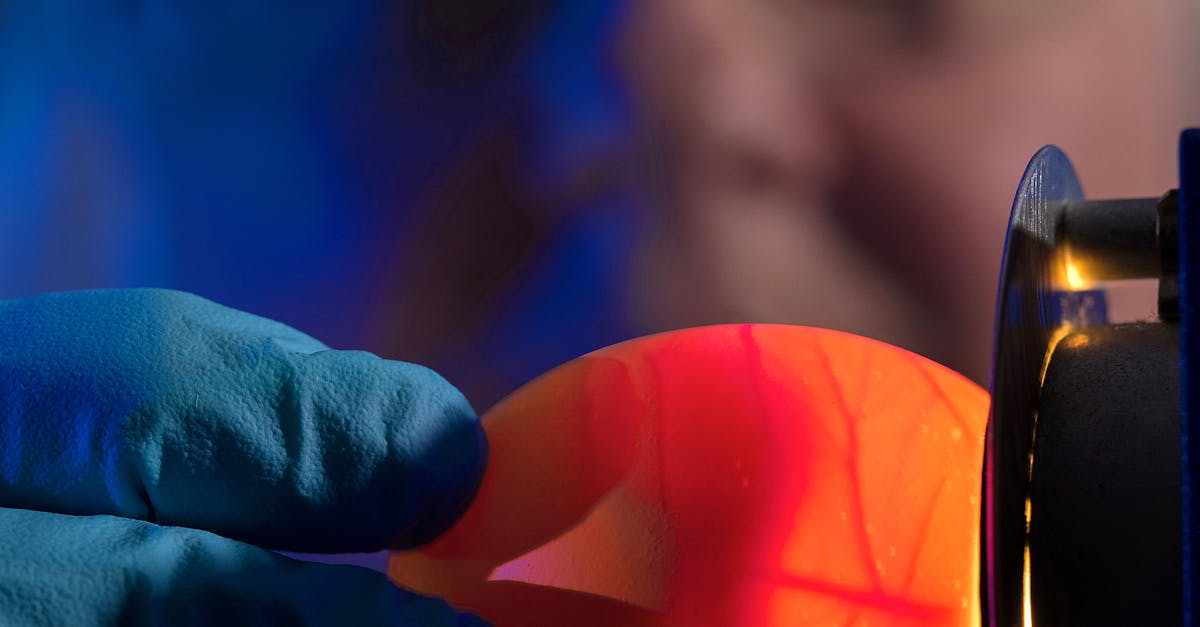 Close-up of scientist examining illuminated egg with candling technique.