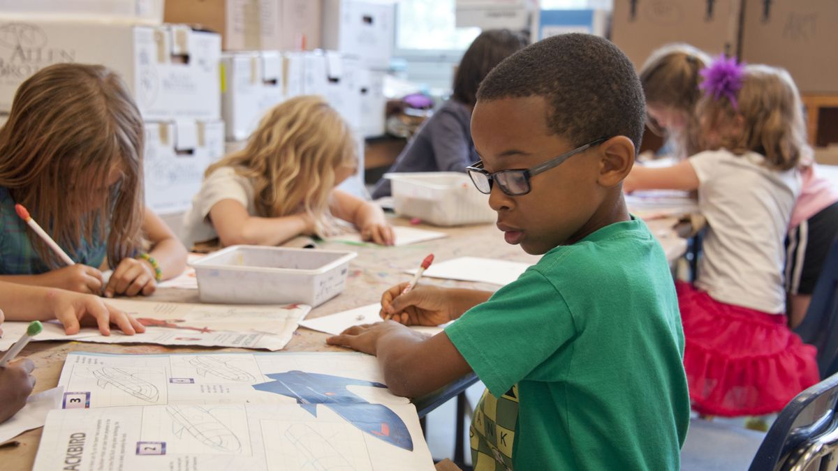 Group of children focused on educational activities in a classroom setting.