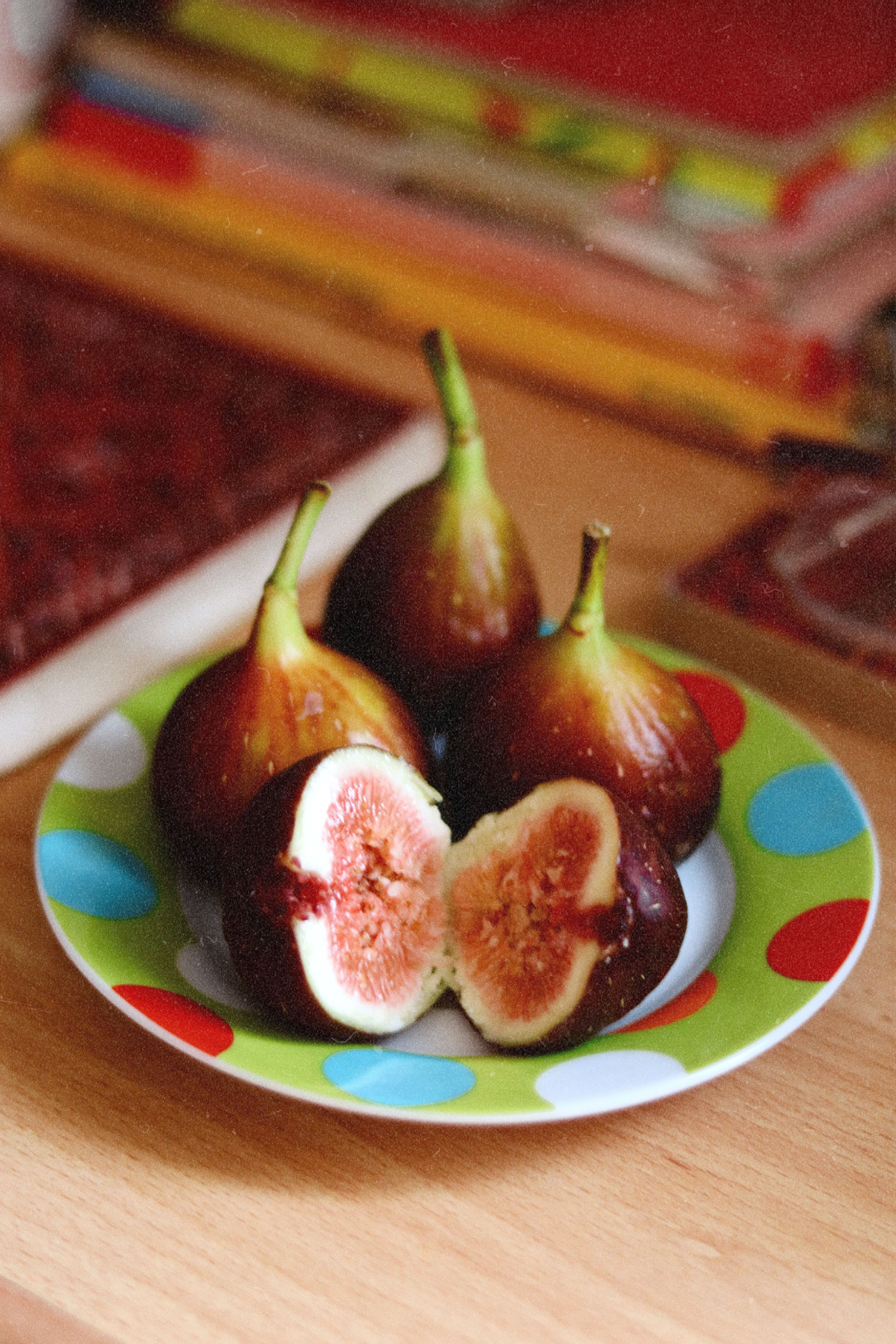 Fotomural Primer plano de higos maduros expuestos en un plato de lunares de colores.