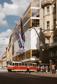 Dynamic street view in Prague featuring a vibrant tram and historical architecture.