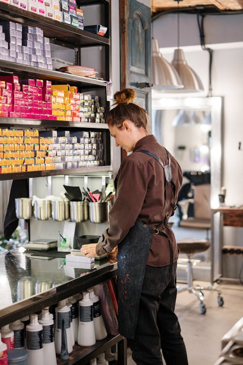 Woman in Brown Jacket Standing in Front of Counter