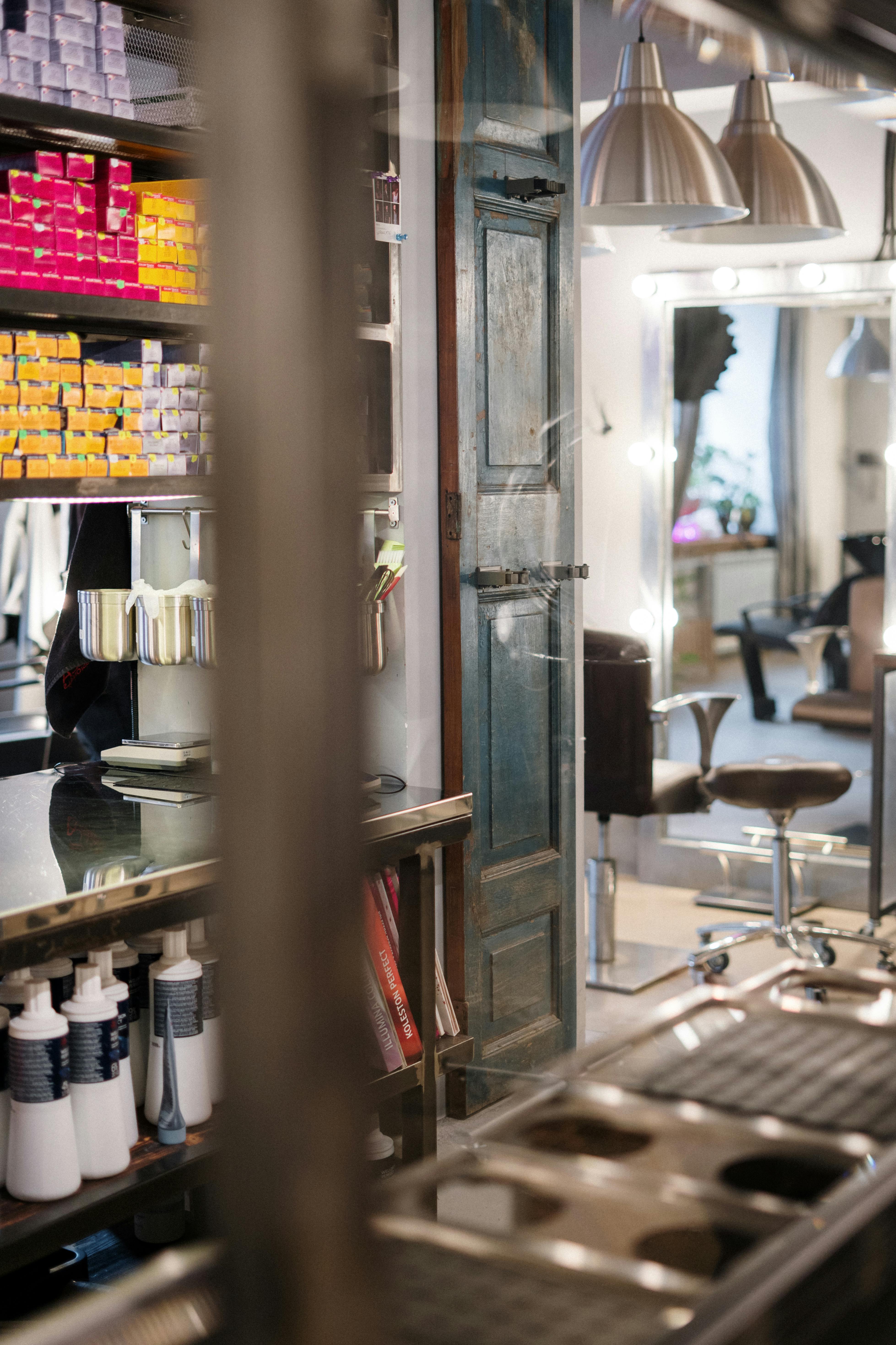 Modern salon interior featuring styling stations and colorful hair products on shelves.