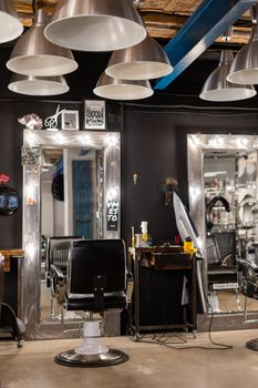 Contemporary hair salon featuring sleek chairs, bright mirrors, and industrial lighting.