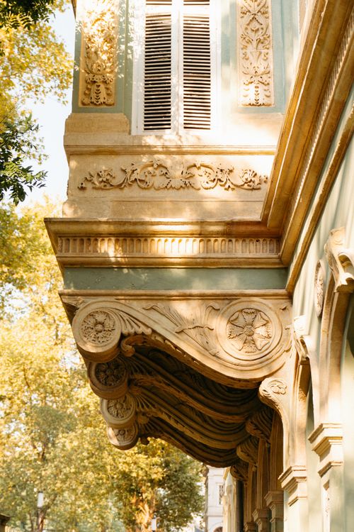 Free Beautiful architectural detail of a historic building with ornate carvings in warm sunlight. Stock Photo
