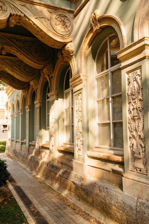 Free A beautifully ornate historical building facade with intricate carvings illuminated by sunlight. Stock Photo