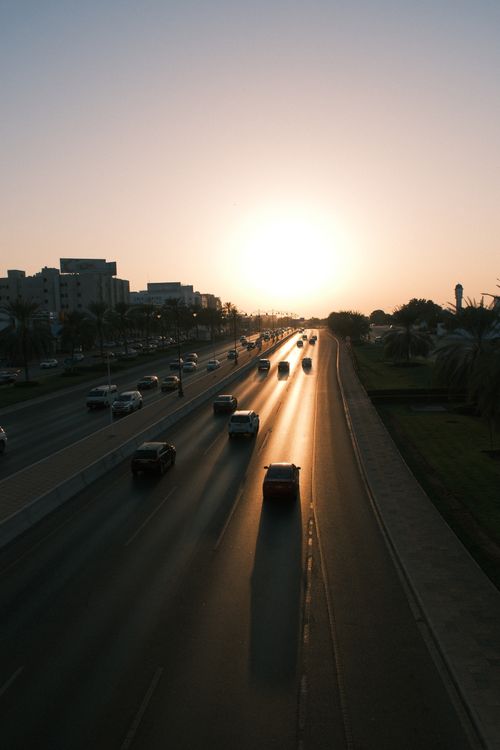 Free Cars drive along a highway in Muscat, Oman, silhouetted against the setting sun. Stock Photo