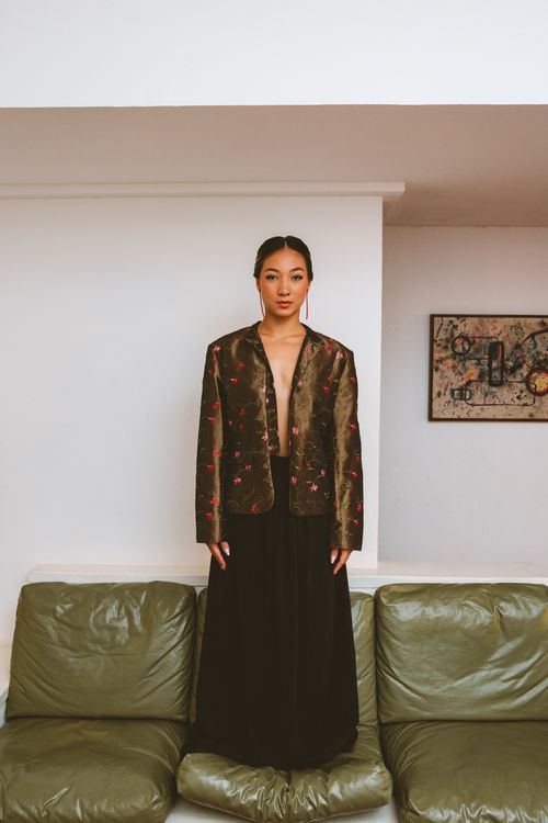 Free Elegant Asian woman in fashionable attire poses indoors with modern decor. Stock Photo