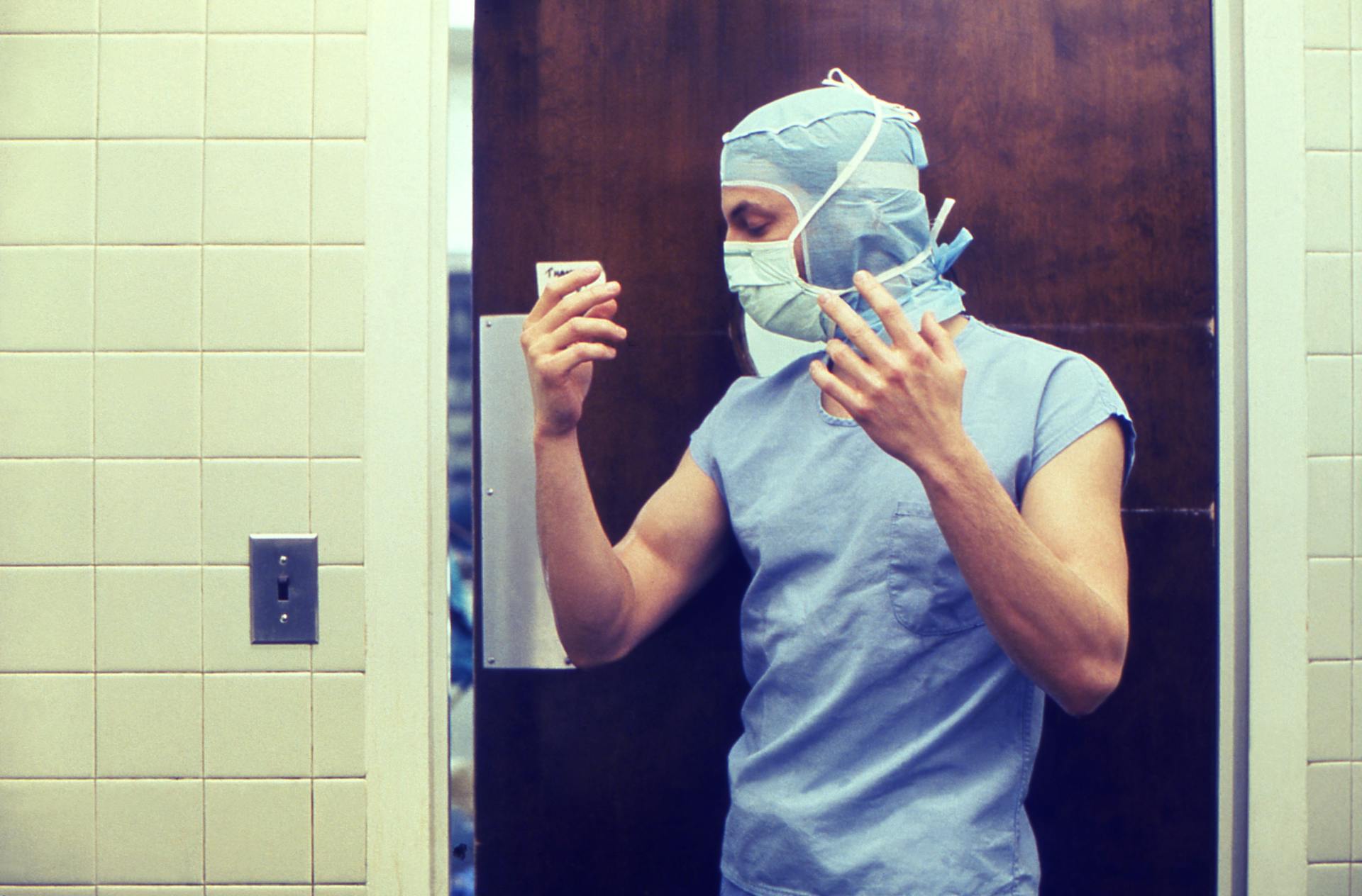 A medical practitioner in full PPE preparing in a hospital setting.