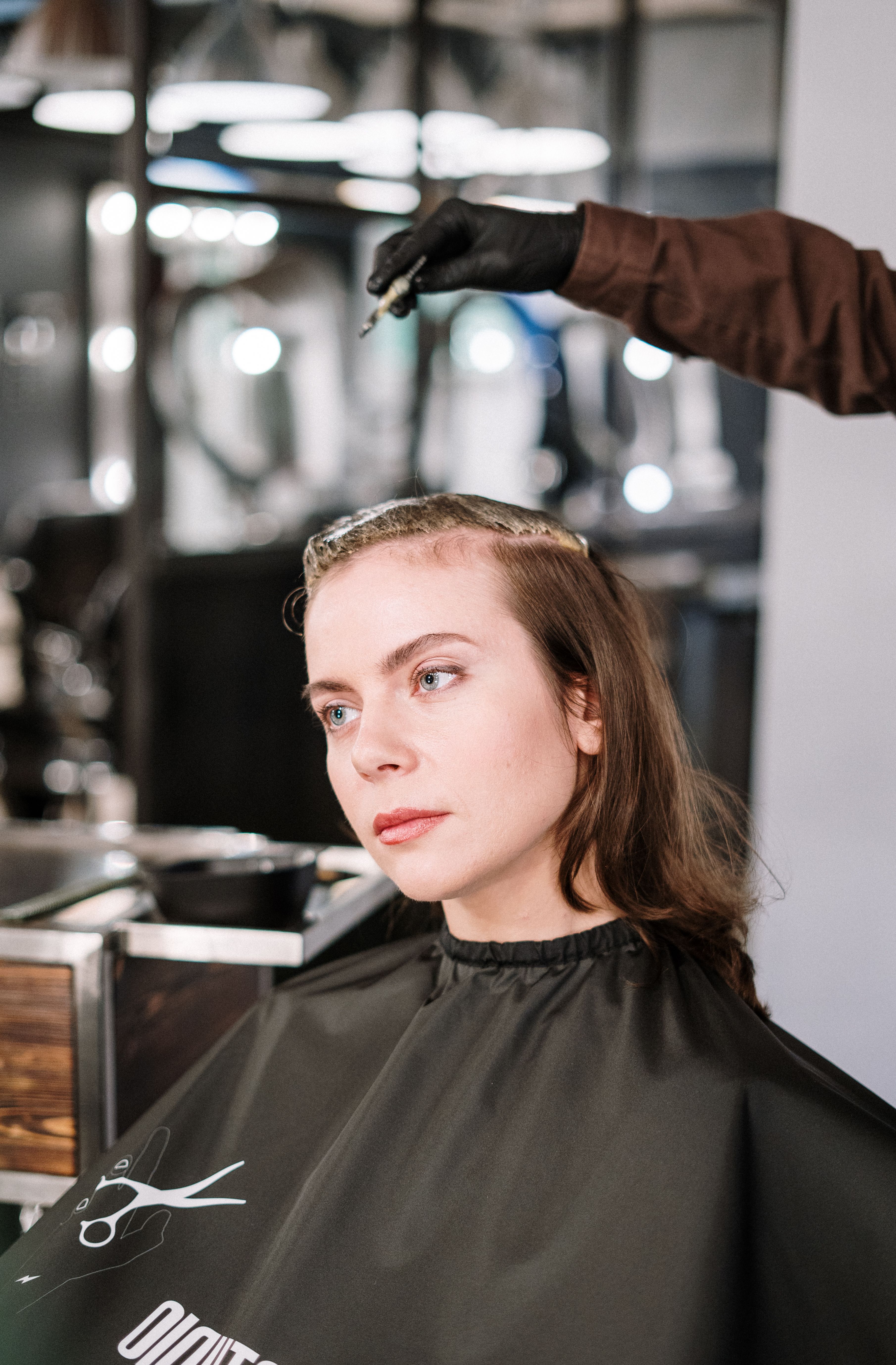our-services-2 Profile of a woman having her hair curled with an iron in a salon setting.