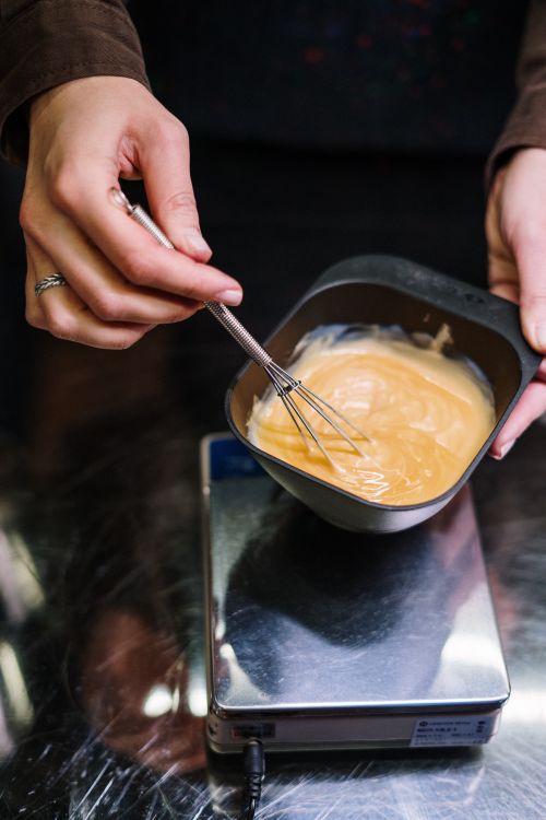 Close-up of hair dye being mixed in a bowl by a stylist