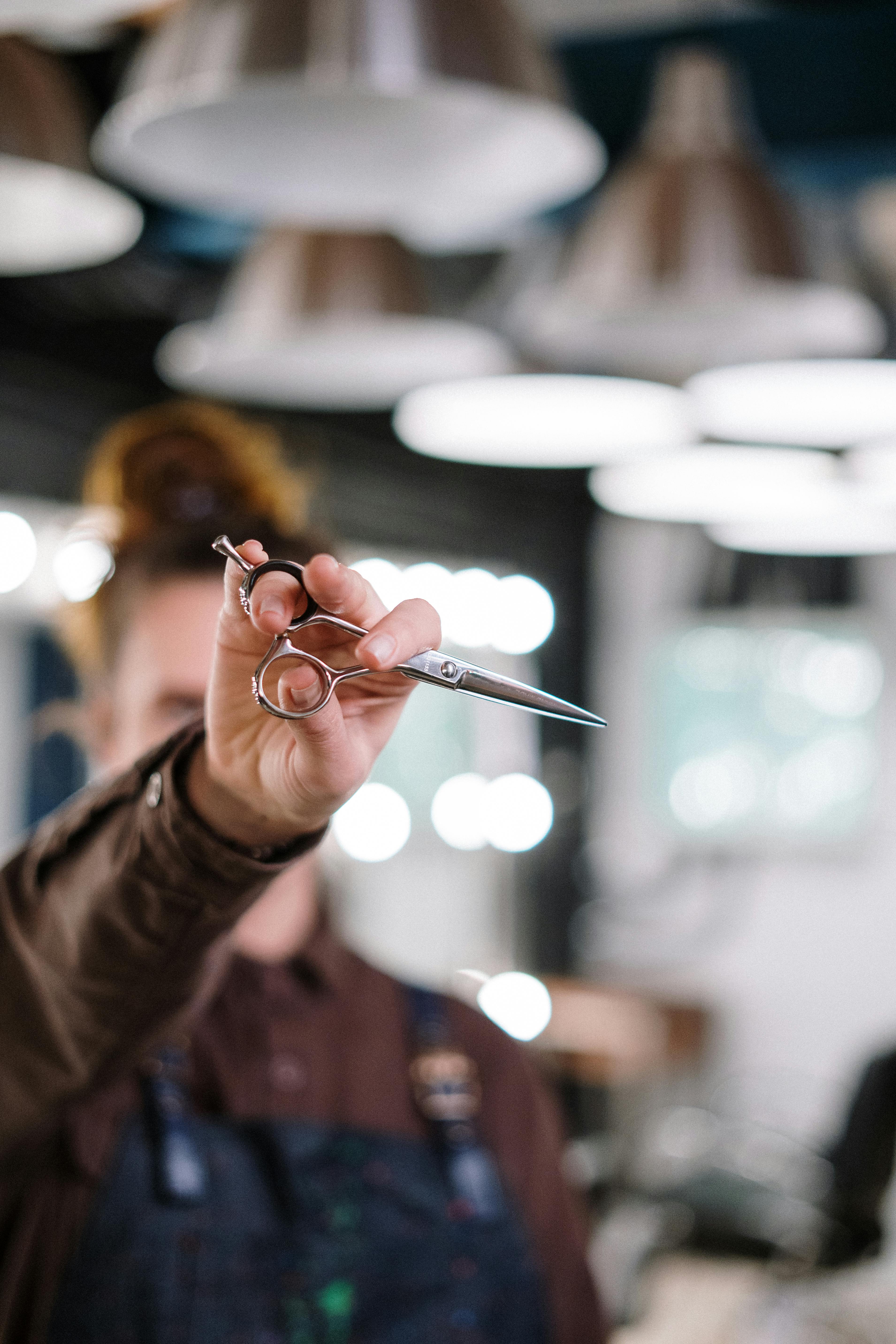 person holding silver scissors