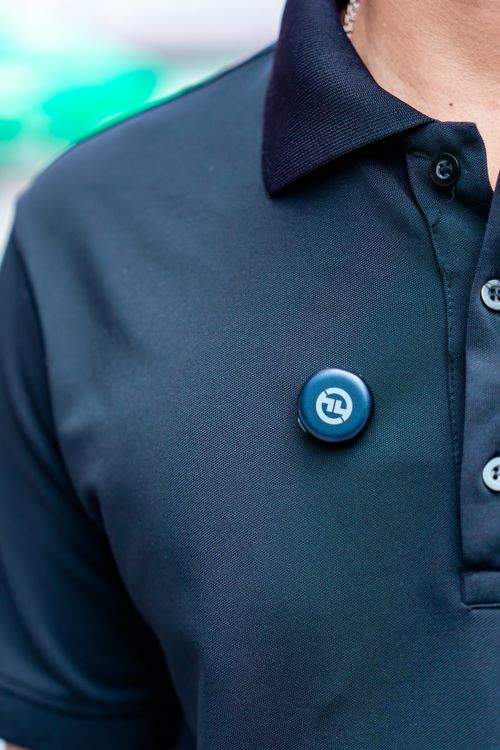 Free Close-up of a navy blue polo shirt featuring a custom button design for branding or personalization. Stock Photo