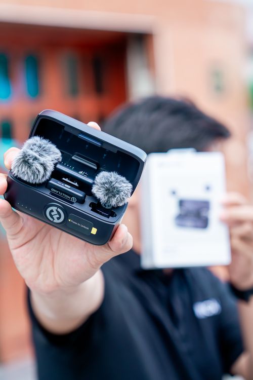 Free Person holding a portable microphone kit with windshields. Ideal for audio recording outdoors. Stock Photo