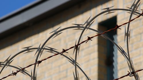 Free Black Metal Wire Fence Near Brown Concrete Building Stock Photo