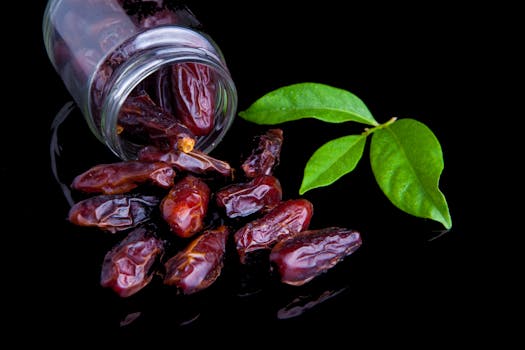 Delicious fresh dates with leaves on a black background, showcasing healthy eating.