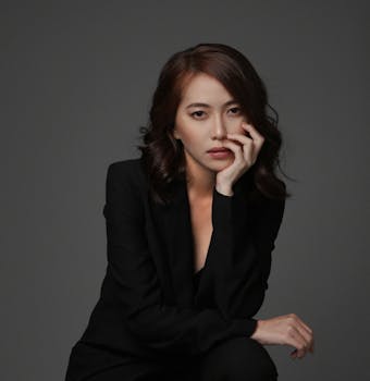 身着经典黑色西装的亚洲女性肖像优雅，散发着自信与优雅