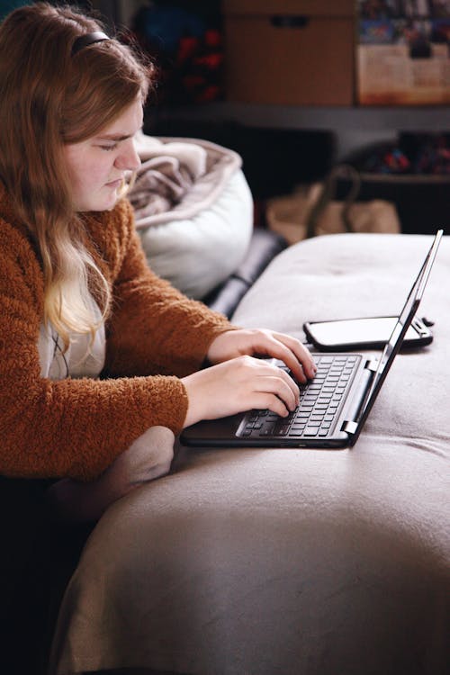 Woman in Brown Sweater Using Laptop Computer