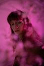 一幅梦幻粉色氛围的女性艺术肖像，运用了创意模糊和灯光效果
