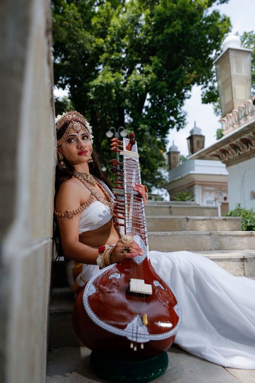 Free Indian model in traditional attire playing a sitar outdoors. Stock Photo