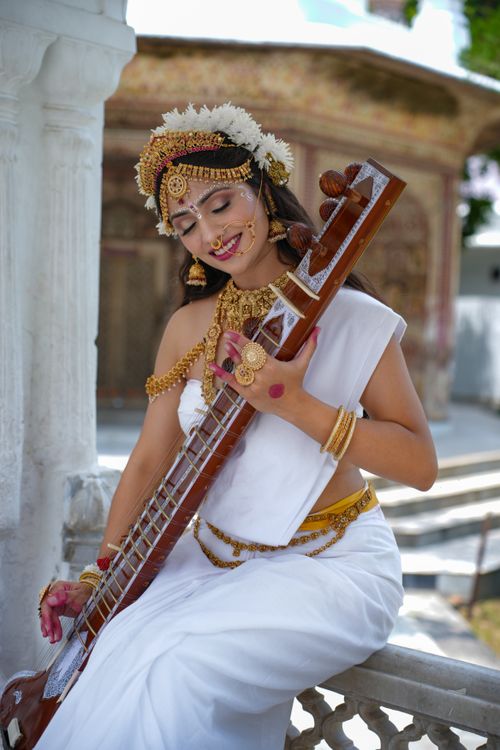 Free Elegant Indian woman in traditional attire playing sitar outdoors, evoking cultural grace. Stock Photo
